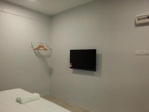 Simpang Renggam的住宿－L Hotel，白色的房间,墙上配有电视