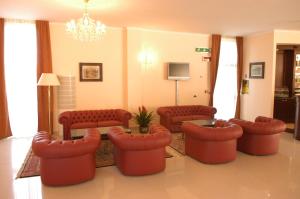 een woonkamer met banken en stoelen en een kroonluchter bij Pilgrim's Hotel in Cicognolo