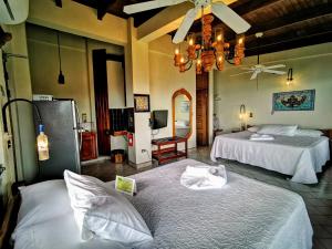 a hotel room with two beds and a chandelier at Hotel Costa Verde in Manuel Antonio