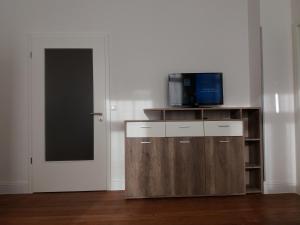 a living room with a tv on a cabinet with a door at Apartment Comfort in Worms