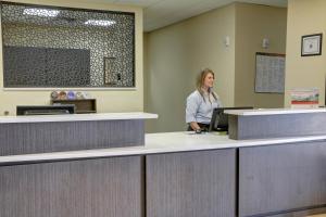 德州特克薩卡納的住宿－特克薩卡納燭木套房酒店，站在候诊室柜台上的女人