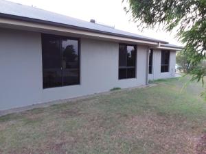 a white house with windows and a yard at Waratah and Wattle Apartments in Maryborough