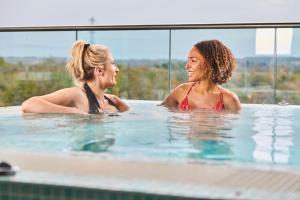 two women are talking in a swimming pool at Genting Hotel & Spa at Resorts World Birmingham in Bickenhill