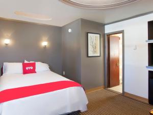 Un dormitorio con una cama roja y blanca y una puerta en OYO Hotel Wilkes-Barre East, en Wilkes-Barre