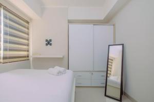 Ένα ή περισσότερα κρεβάτια σε δωμάτιο στο Minimalist and Posh 1BR The Oasis Cikarang Apartment By Travelio