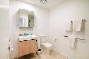 a bathroom with a toilet and a sink and a mirror at Hope Street Apartments by CLLIX in Brisbane