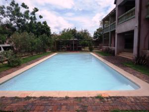 a large blue swimming pool next to a building at The Cottage in Hoedspruit