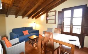 sala de estar con sofá azul y mesa en Apartamentos Rurales Villa Carla, en Quintana de Llanes
