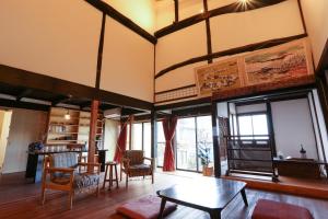 Guesthouse Izame Ann في Nagaoka: غرفة معيشة مع طاولة وكراسي
