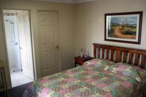 - une chambre avec un lit et une photo sur le mur dans l'établissement Banksia and Acacia Apartments, à Maryborough