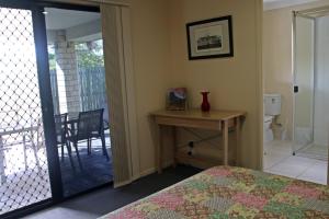 
a bedroom with a bed and a dresser at Banksia and Acacia Apartments in Maryborough
