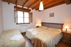 a bedroom with two beds and a window at Apartamentos La Huertina in Canales