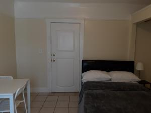 a bedroom with a bed and a table and a door at Pads on Pasadena Ave in Los Angeles