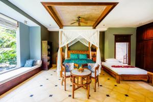 um quarto com uma cama, uma mesa e cadeiras em Villa Beji Indah em Ubud