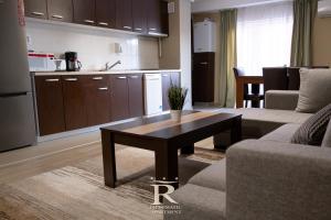 ein Wohnzimmer mit einem Tisch und einer Küche in der Unterkunft Apartament Modern Rivulus 28 in Baia Mare