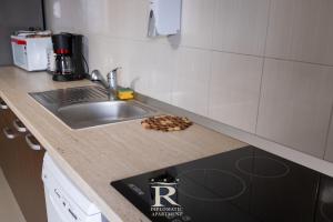 a kitchen with a sink and a counter top with mushrooms at Apartament Modern Rivulus 28 in Baia Mare +6 photos