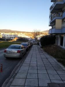 una fila de autos estacionados al lado de una calle en Maria’s house, en Tesalónica