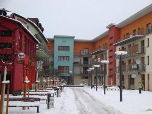 eine schneebedeckte Straße in einer Stadt mit Gebäuden in der Unterkunft Apartmán Borgi in Oščadnica