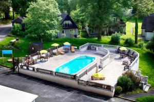 a swimming pool with chairs and umbrellas next to a house at Rock Cottage in Callington