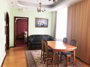 a dining room with a table and chairs and a couch at Slavyanka in Moscow