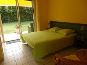 a bedroom with a bed and a sliding glass door at Locatlantique in Aytré