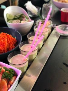 バイユーにあるカンパニール バイユーのピンクのプラスチックストローを使った料理のビュッフェ