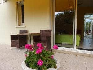 a patio with a table and some pink flowers at Locatlantique in Aytré
