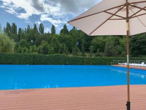 una sombrilla blanca sentada junto a una piscina azul en Sokol Hotel, en Saratov