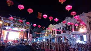 a group of pink lanterns hanging over a street at night at Thian Siong Inn in Melaka