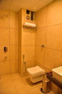 La salle de bains est pourvue de toilettes, d'une douche et d'un lavabo. dans l'établissement Le Oak Inn, à Mysore