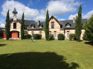 a large house with a grass yard in front of it at La Bretauche in Chécy