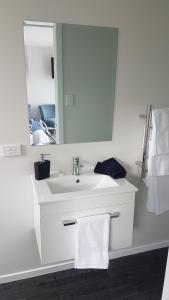 a bathroom with a white sink and a mirror at Lodges on Pearson - Unit 2 in Cromwell