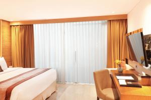 Postel nebo postele na pokoji v ubytování de Vins Sky Hotel Seminyak