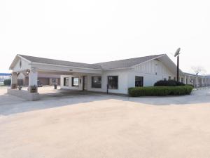 a large white building with a parking lot at OYO Hotel DeRidder Hwy 171 North in DeRidder