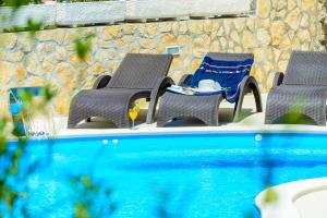 3 sillas y una mesa junto a la piscina en Villa Ida, en Dubrovnik