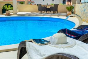 a hat sitting on a table next to a swimming pool at Villa Ida in Dubrovnik