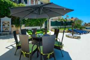 einen Tisch und Stühle mit Sonnenschirm auf einer Terrasse in der Unterkunft Villa Ida in Dubrovnik