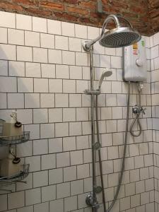 una ducha con cabezal de ducha en una pared de azulejos en PX122 DBEST HOTEL en Nan