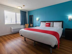 a large bedroom with a large bed with blue walls at OYO Hotel DeRidder Hwy 171 North in DeRidder