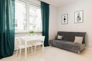 a living room with a table and a couch at Apartments Gdynia Abrahama in Gdynia