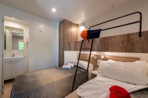 a bedroom with a bed and a lamp on the wall at Camping Village Il Poggetto in Troghi