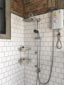 a shower in a bathroom with white tiles at PX122 DBEST HOTEL in Nan