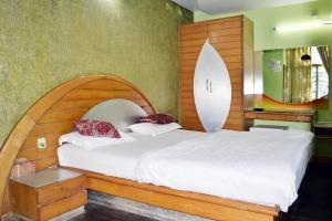 a bedroom with a bed with a surfboard on the wall at Hotel Swagat in Mount Ābu