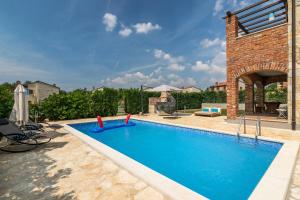 einen Pool in einem Garten mit einem Backsteingebäude in der Unterkunft Paradis Villa Ana in Butkovići