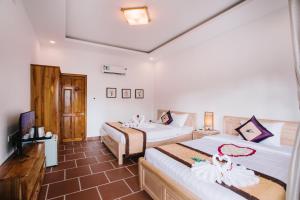 a hotel room with two beds and a television at Palm Hills Resort in Phu Quoc