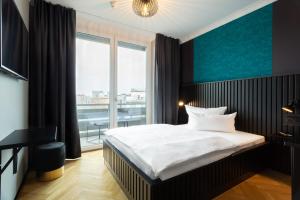 a bedroom with a bed and a large window at 133 Boutique Hotel in Karlsruhe