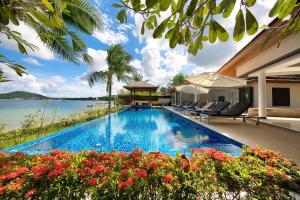 a swimming pool with a view of the water at Dhevatara Residence Beachfront Villas in Mae Nam