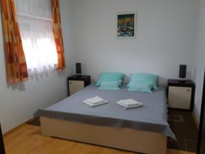 a bedroom with a bed with two towels on it at Apartment Sky in Korenica