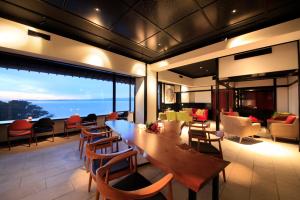 a living room with a wooden table and chairs at Nishiizu Koyoi in Numazu