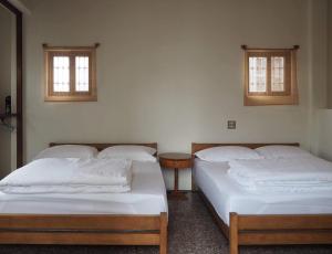 two beds in a room with two windows at H. 1967 in Changhua City
